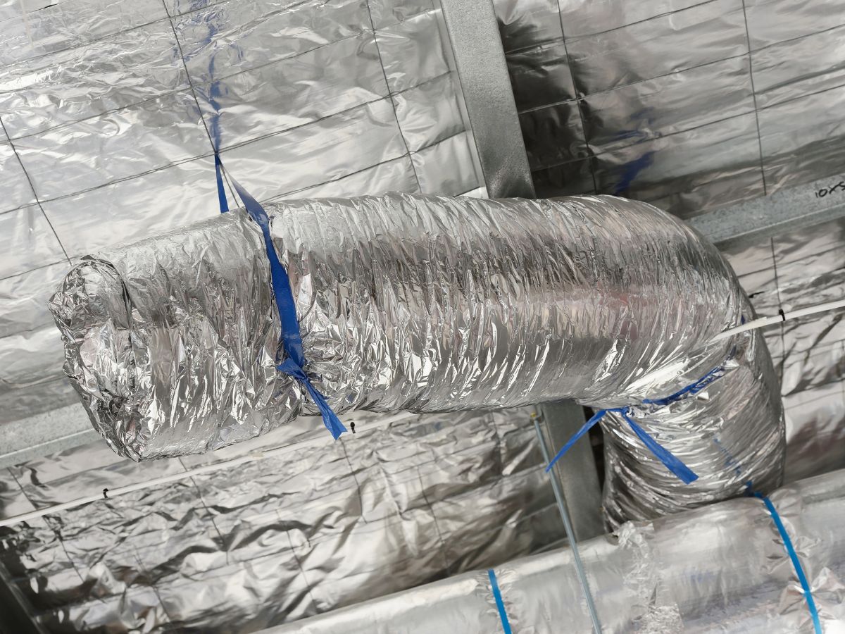 A metal duct secured with duct tape, showcasing the connection of ducting in a ventilation system.