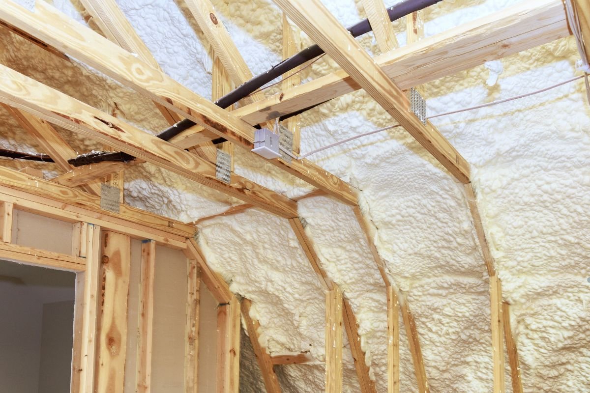 Insulation material installed in an attic, surrounded by wooden framing, highlighting an insulation service setup.