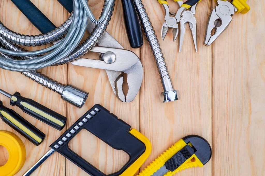A wooden table displaying various tools, including wrenches, screwdrivers, and pliers, arranged neatly for easy access.